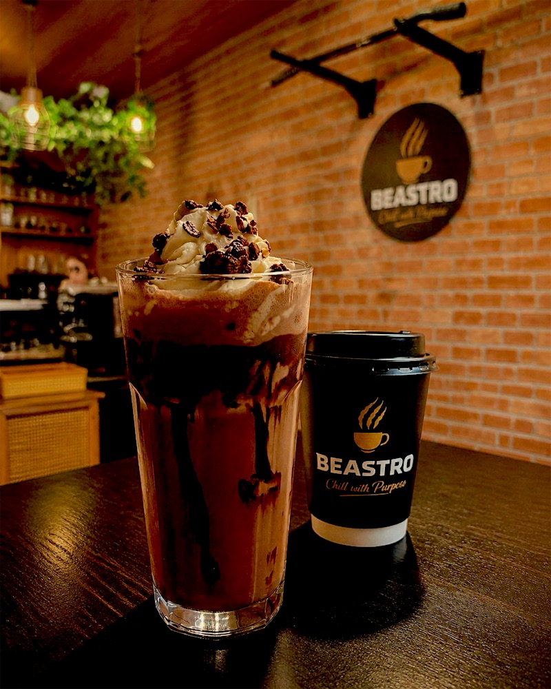 Chocolate Beast protein shake with whipped cream beside a Beastro cup