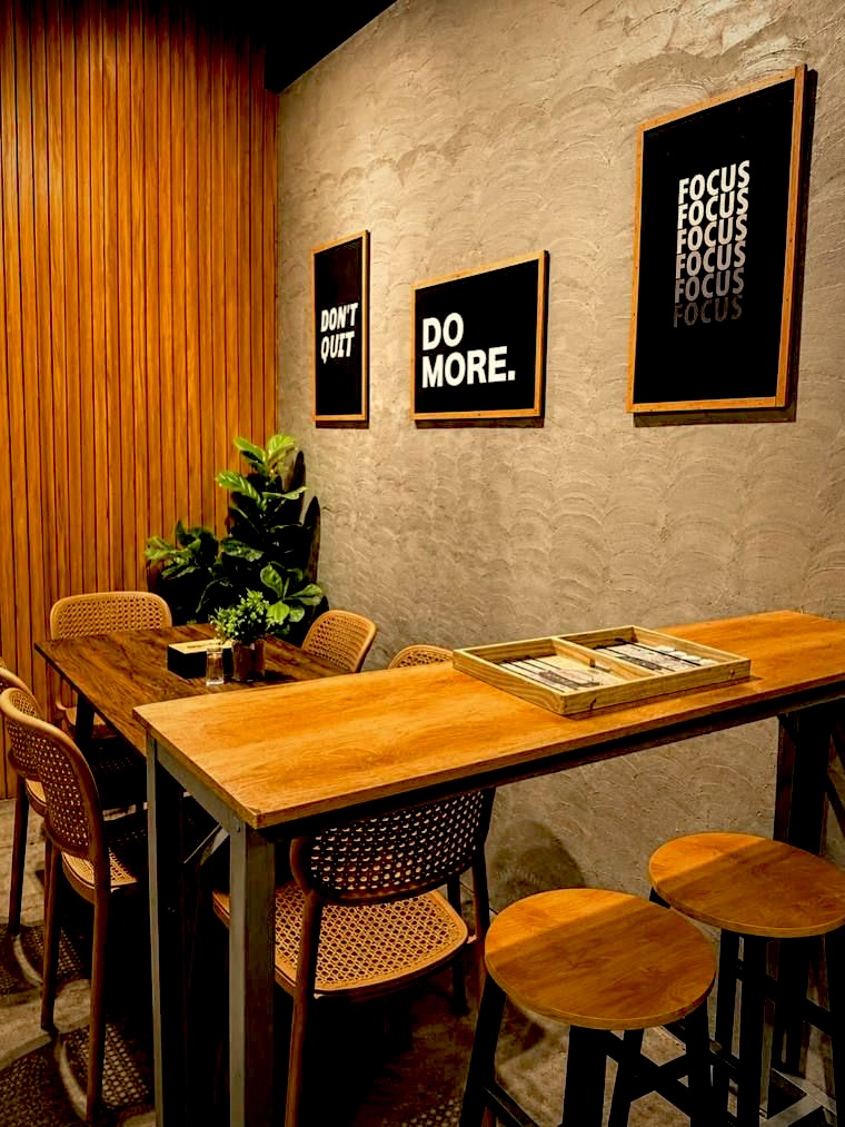 Wall prints reading Do More and Don't Quit above a wooden table
