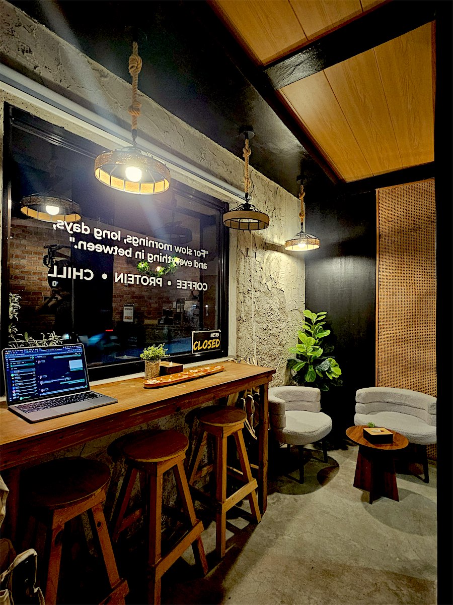 Window bar with wooden stools and the Coffee, Protein, Chill decal